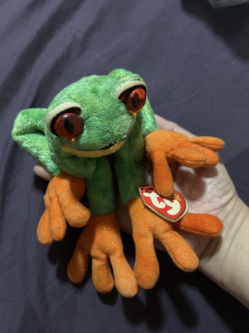 Ty Beanie Babies "Ribbit" Frog Plush Toy (Category: Plushies & Soft Toys) located in Pasig City. Submitted by mixpicks (Listing ID 1460306409, Image 3). Description: - Adorable green frog plush toy - Features big red eyes - Sparkly orange feet add a unique touch - Original Ty tag still attached - Ideal for Ty collectors or as a charming gift - A fun and friendly companion - Vintage stuff ( owned for a long time).