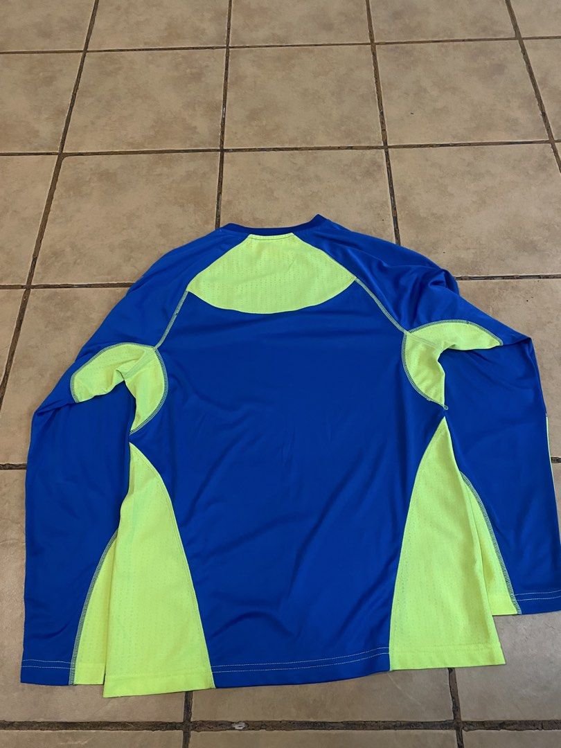 Under Armour Long Sleeve Athletic Shirt (Category: Tshirts & Polo Shirts ) located in Manila. Submitted by sebthrift (Listing ID 1460359927, Image 2). Description: - Blue and neon yellow Under Armour long sleeve shirt - Great for sports, workouts, running, or training - Breathable material for comfort - Features Under Armour logo on the front - Back design includes mesh panels for ventilation.