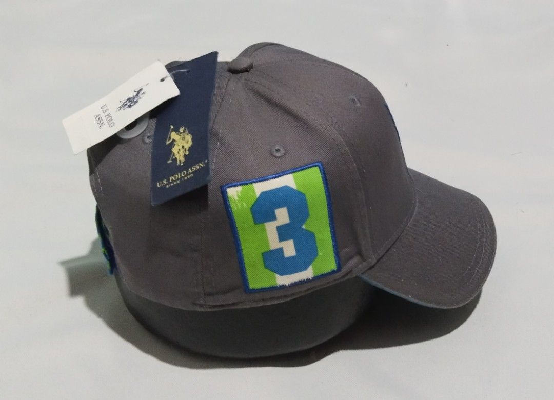 U.S. Polo Assn. Grey Baseball Cap with Number 3 Patch (Category: Caps & Hats) located in Manila. Submitted by wanchi0624 (Listing ID 1460359234, Image 3). Description: - Brand: U.S. Polo Assn. - Color: Grey - Design: Classic polo player logo embroidered in blue on the front. - Accent: Side patch with blue number '3' on green/white background. - Material: 100% Cotton - Condition: Brand new with tags attached..