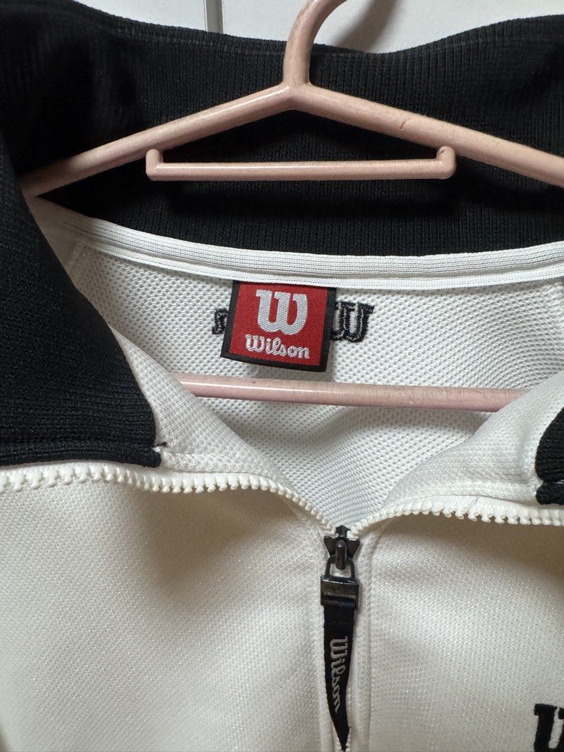 Wilson USA Track Jacket (Category: Coats, Jackets and Outerwear) located in Manila. Submitted by quintessesommerset (Listing ID 1460502434, Image 3). Description: - Classic white Wilson track jacket 23.5x27 - Black accent details - Embroidered Wilson logo and "Chicago U.S.A." on chest - Zip-up front closure - Stand-up collar - Ribbed cuffs and hem - Ideal for casual wear or sports activities.