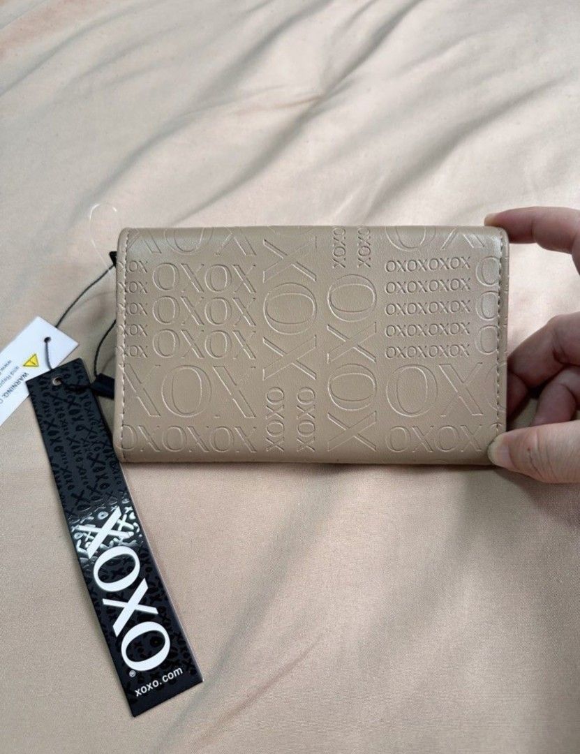 XOXO Beige Embossed Hearts Tri-Fold Wallet (Category: Wallets & Card holders) located in Las Pinas. Submitted by skylarkt (Listing ID 1460440769, Image 2). Description: - Trifold Wallet - Adorable beige XOXO wallet - Features all-over embossed XOXO pattern - Cute black heart detail on the front flap - Interior card slots for organization - Convenient zippered coin pocket - Comes with original tags attached.