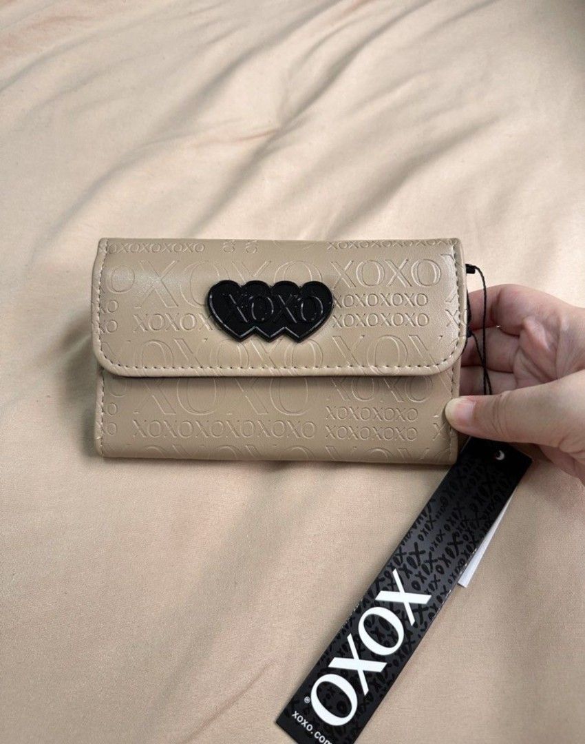 XOXO Beige Embossed Hearts Tri-Fold Wallet (Category: Wallets & Card holders) located in Las Pinas. Submitted by skylarkt (Listing ID 1460440769, Image 1). Description: - Trifold Wallet - Adorable beige XOXO wallet - Features all-over embossed XOXO pattern - Cute black heart detail on the front flap - Interior card slots for organization - Convenient zippered coin pocket - Comes with original tags attached.
