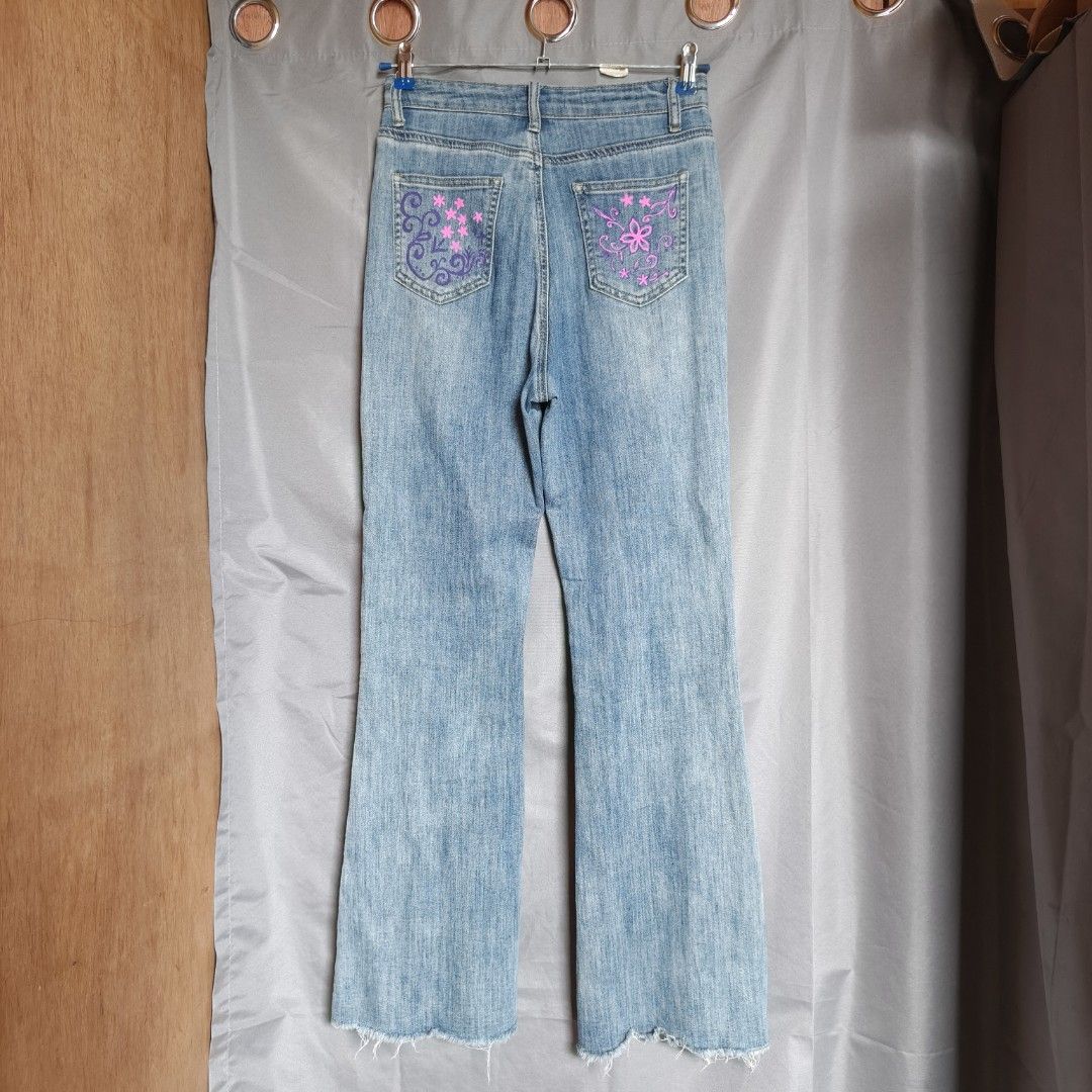 Y2K Flare Jeans - Light Wash Stretch Denim (Category: Jeans) located in Alfonso Lista (Potia). Submitted by ak_collection.03 (Listing ID 1460347130, Image 2). Description: Style: Trendy Y2K aesthetic with unique, custom purple hand-painted floral and vine details. Fabric: Soft and highly stretchable denim for a comfortable, flattering fit. Cut: Classic high-waisted flare leg with a stylish raw, frayed hem. Condition: Lightly used and in excellent