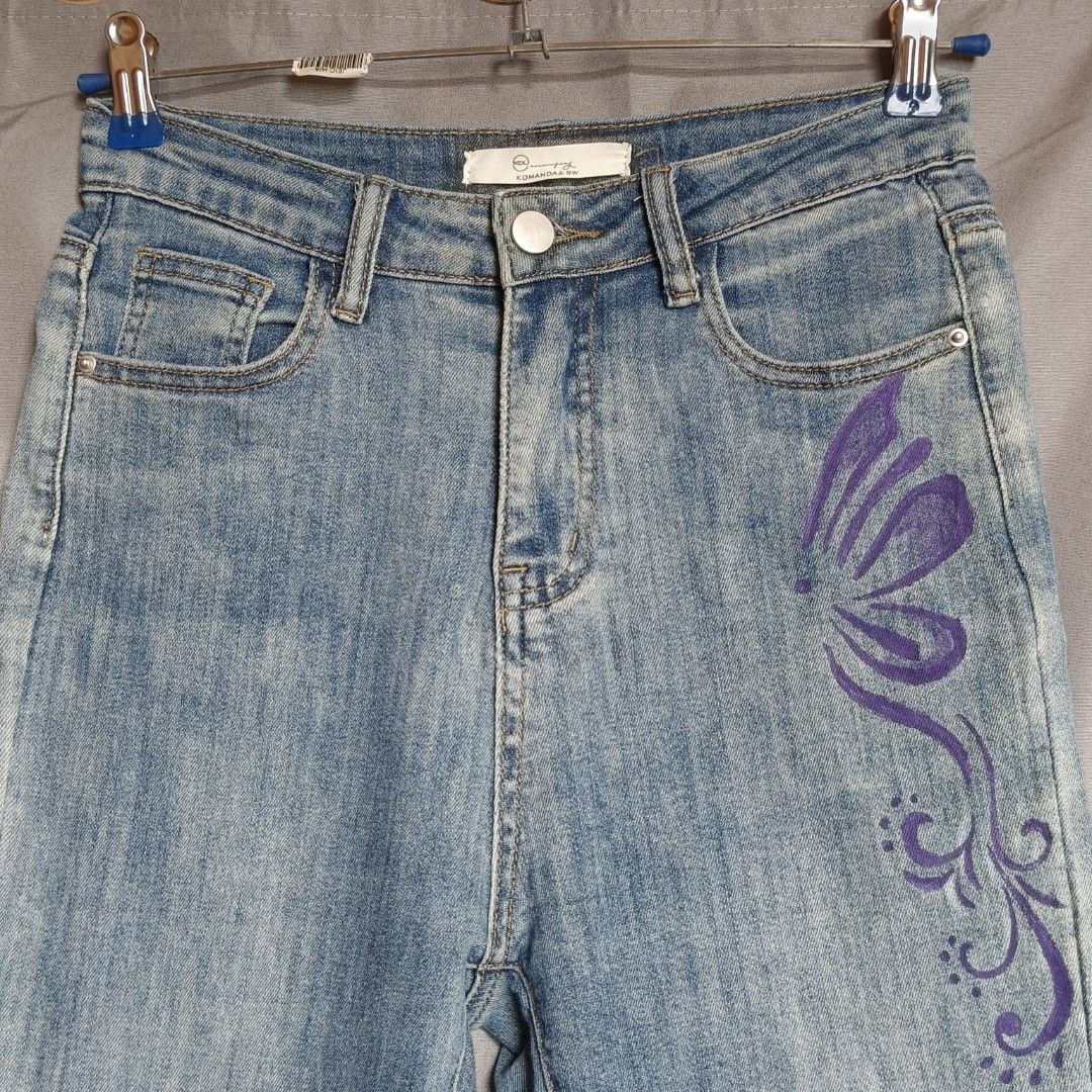 Y2K Flare Jeans - Light Wash Stretch Denim (Category: Jeans) located in Alfonso Lista (Potia). Submitted by ak_collection.03 (Listing ID 1460347130, Image 3). Description: Style: Trendy Y2K aesthetic with unique, custom purple hand-painted floral and vine details. Fabric: Soft and highly stretchable denim for a comfortable, flattering fit. Cut: Classic high-waisted flare leg with a stylish raw, frayed hem. Condition: Lightly used and in excellent