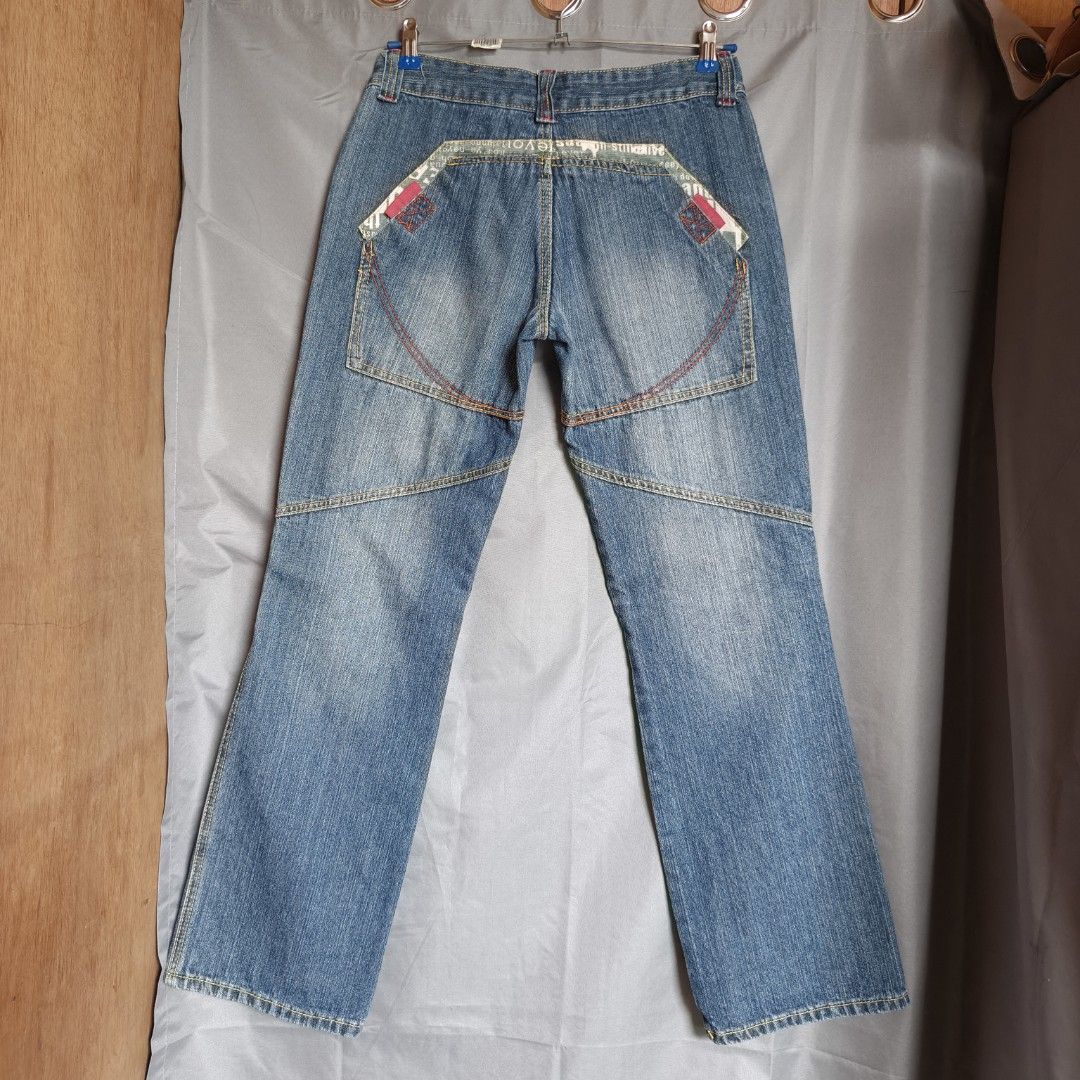 Y2K Low Rise Utility Jeans (Category: Jeans) located in Alfonso Lista (Potia). Submitted by ak_collection.03 (Listing ID 1460350330, Image 2). Description: Like New condition. Early 2000s Y2K fashion style blue denim. Features unique statement front flap pockets with patterned trim, knee panel stitching, and a trendy low-to-mid rise fit. Heavy-duty utility streetwear aesthetic. Brand: Zhiligao Tag Size: 28 Waist Measurement: 30 inches (mid waist)