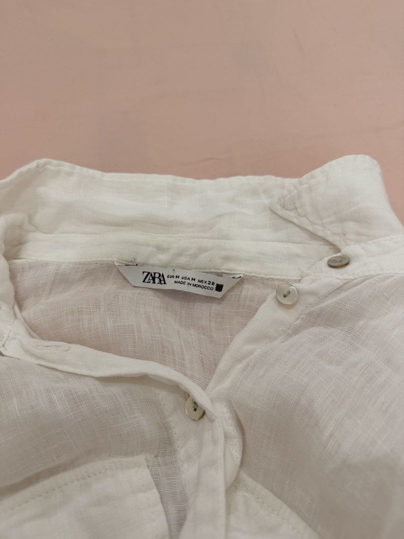 ZARA LINEN BLEND CROPPED SHIRT (Category: Shirts) located in Abulug. Submitted by joysmithznjo (Listing ID 1460422101, Image 2). Description: - White ZARA shirt - Linen blend material - Cropped style with tie front - Button-up closure - Two chest pockets - Long sleeves with button cuffs - Versatile styling: looks great tied or untied.