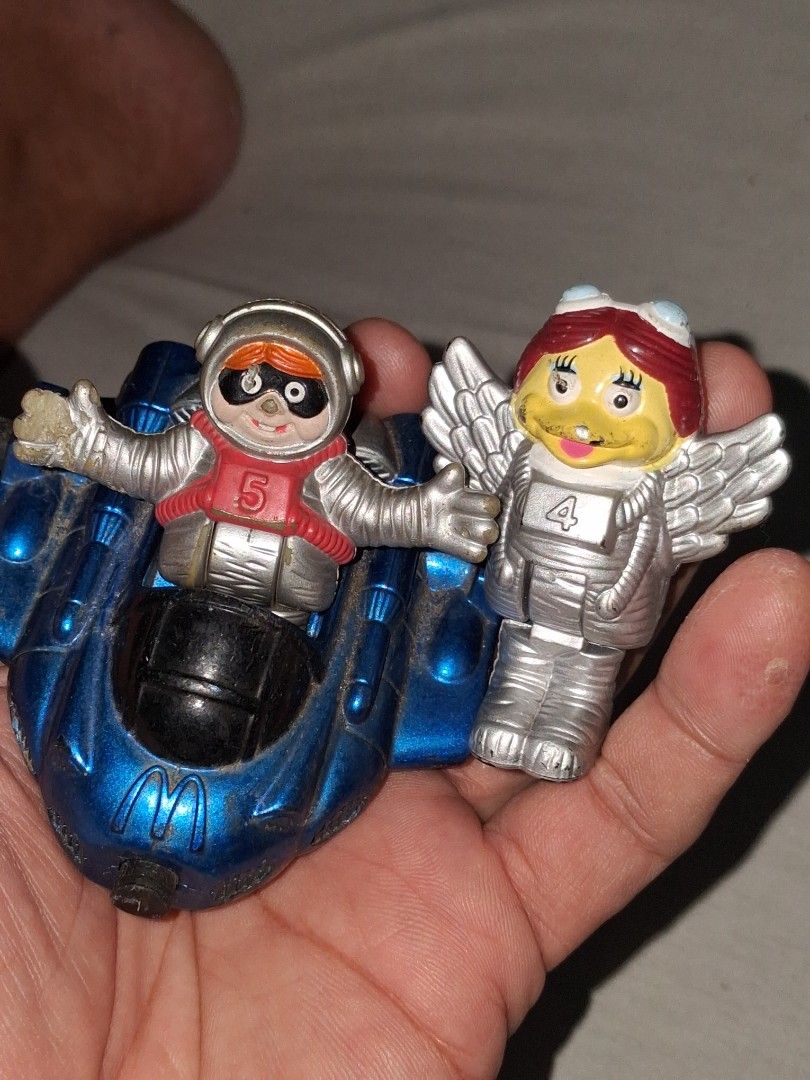 2000 McDonald's Happy Meal Toy - Space Figures (Category: Character Goods) located in Manila. Submitted by marcas022798212 (Listing ID 1460618569, Image 1). Description: - Set of 2 McDonald's Happy Meal toys from the year 2000. - Includes a winged figure with a red helmet (McDonald's logo). - Includes an astronaut figure in a red suit and mask (McDonald's logo). - Both figures attach to a blue rocket vehicle with wheels. - Ideal for collectors or