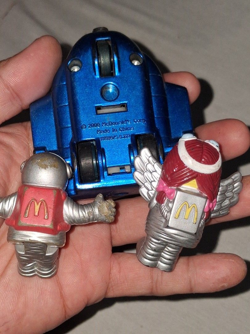 2000 McDonald's Happy Meal Toy - Space Figures (Category: Character Goods) located in Manila. Submitted by marcas022798212 (Listing ID 1460618569, Image 2). Description: - Set of 2 McDonald's Happy Meal toys from the year 2000. - Includes a winged figure with a red helmet (McDonald's logo). - Includes an astronaut figure in a red suit and mask (McDonald's logo). - Both figures attach to a blue rocket vehicle with wheels. - Ideal for collectors or