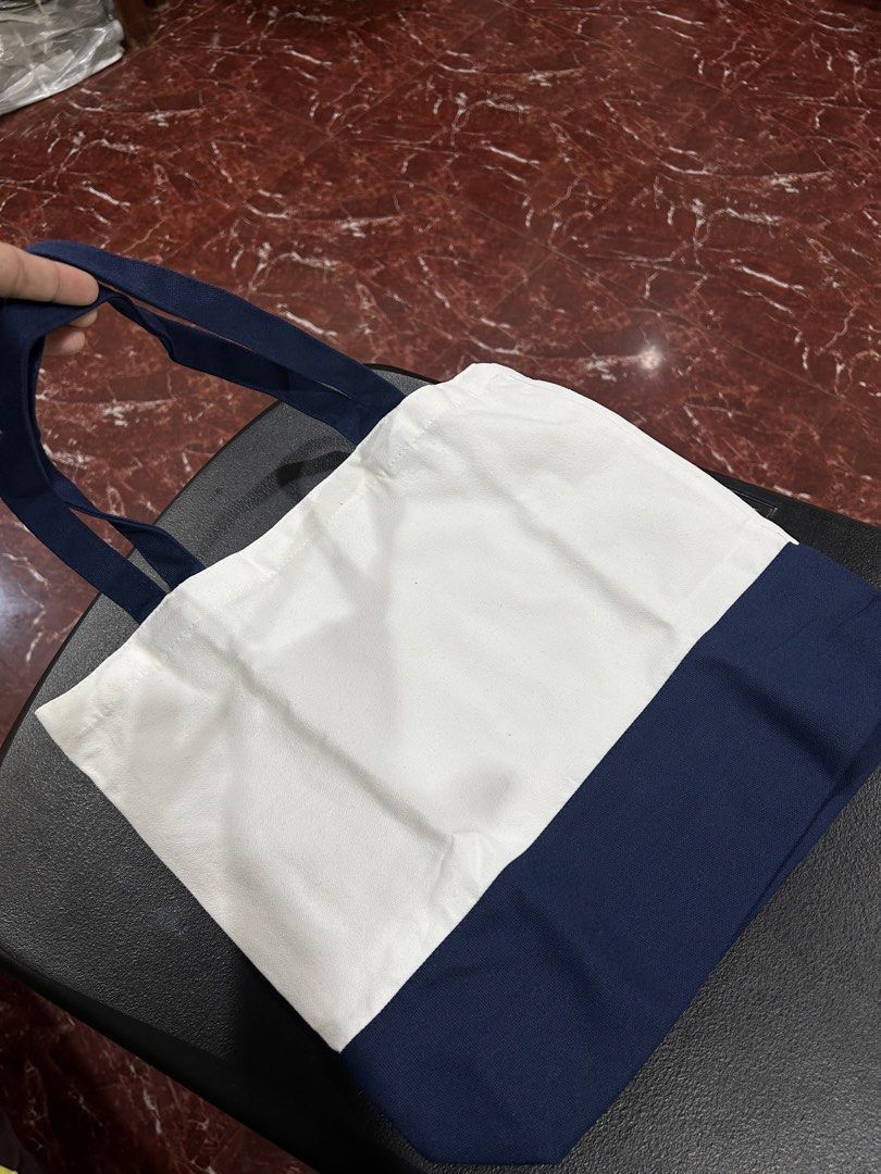 A Bathing Ape Tote Bag (Category: Tote Bags) located in Manila. Submitted by drilskie0954204 (Listing ID 1460516086, Image 3). Description: - Classic A Bathing Ape (BAPE) tote bag - Color: White canvas with navy blue accents - Features the iconic BAPE ape logo - Ideal for everyday use - Spacious interior for essentials - Simple and stylish design.