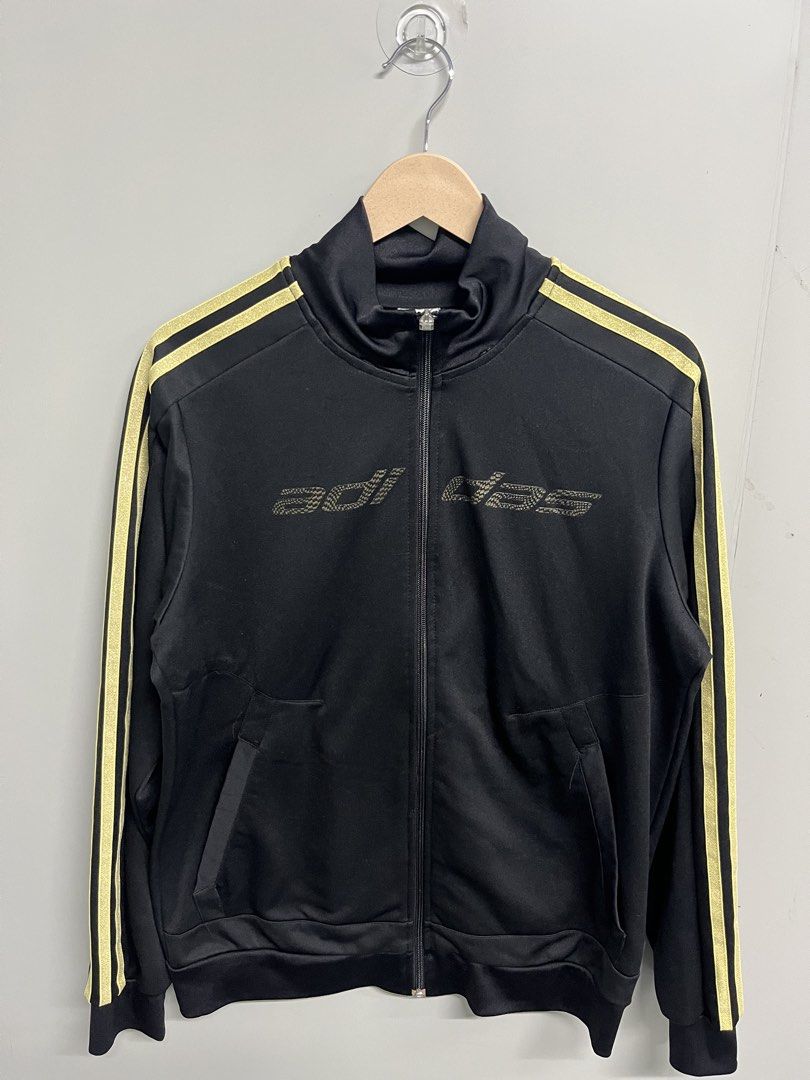 Adidas Black & Gold Full-Zip Track Jacket (Category: Coats, Jackets and Outerwear) located in Valencia. Submitted by shopstnd (Listing ID 1460698593, Image 1). Description: Adidas Black & Gold Full-Zip Track Jacket Size: L 📏 Measurements: 22 × 28 in ⭐ Condition: 9/10 🎨 Color: 9/10 *Black with metallic gold 3-stripes and Adidas detailing *Full-zip track jacket with side pockets Minimal signs of use. Please refer to photos for actual condition an