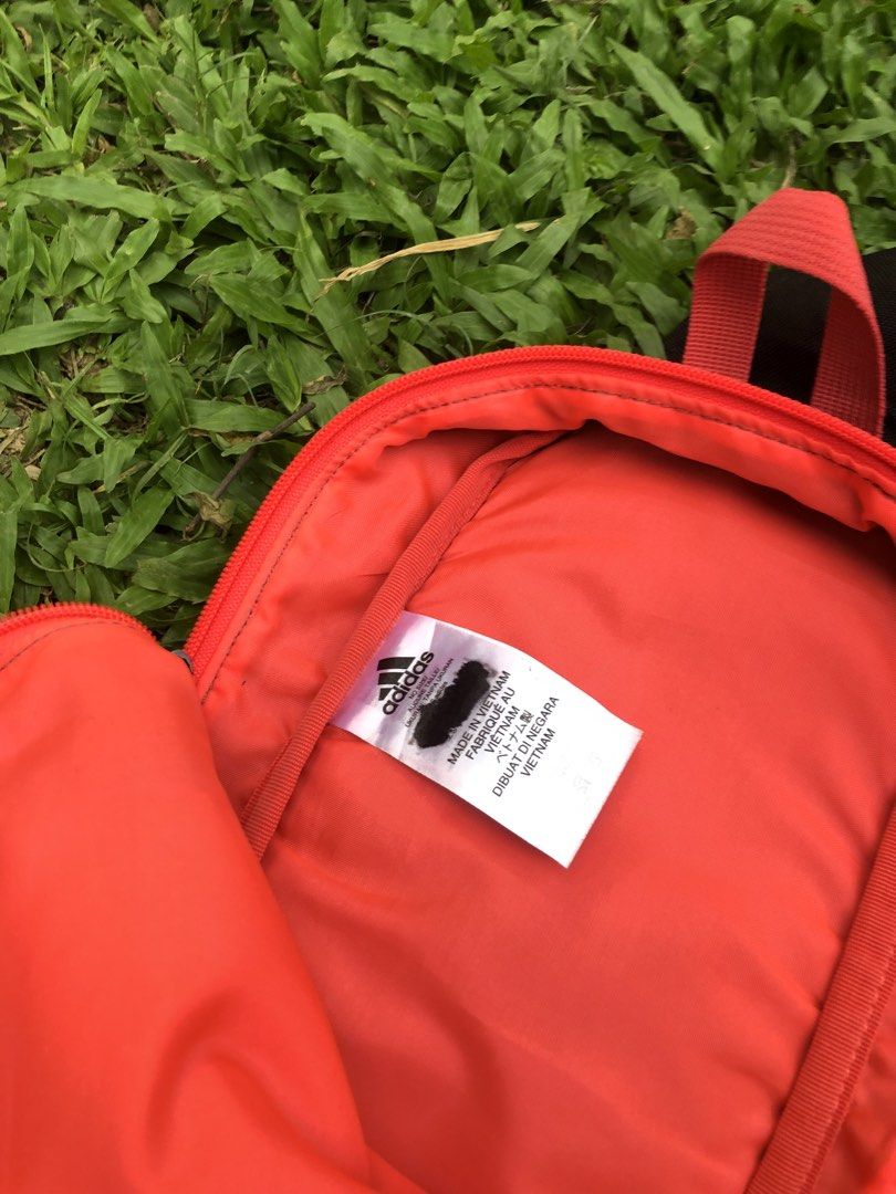 Adidas Mini Black Red Grey Sling Bag (Category: Backpacks) located in Kabasalan. Submitted by hamugaway (Listing ID 1460521953, Image 3). Description: - Adidas mini backpack - Color: Black with grey panels and red accents - Features a front zip pocket - Bright orange interior lining - Made in Vietnam - Ideal for carrying your essentials.