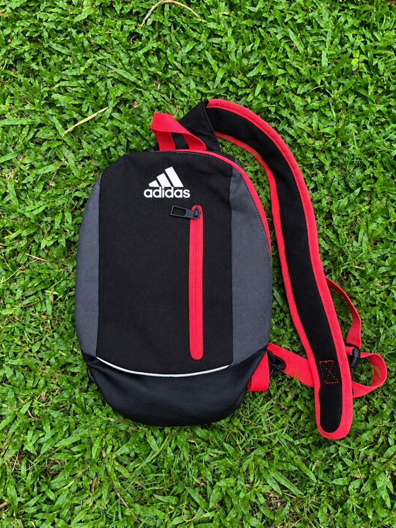 Adidas Mini Black Red Grey Sling Bag (Category: Backpacks) located in Kabasalan. Submitted by hamugaway (Listing ID 1460521953, Image 1). Description: - Adidas mini backpack - Color: Black with grey panels and red accents - Features a front zip pocket - Bright orange interior lining - Made in Vietnam - Ideal for carrying your essentials.