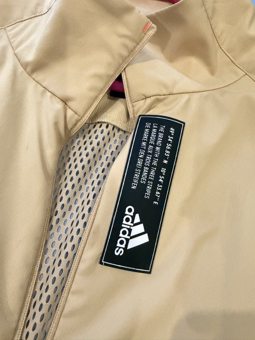Adidas Windbreaker Jacket Beige Size M (Category: Coats, Jackets and Outerwear) located in Manila. Submitted by iamemmc (Listing ID 1460608758, Image 2). Description: - Lightweight beige Adidas jacket - Breathable mesh back panel - Full zip front closure - Elasticated cuffs and hem - Made with sustainable Primeblue material - Ideal for outdoor activities and casual styling.