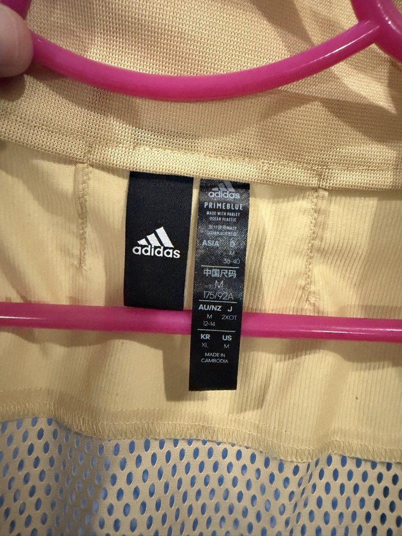 Adidas Windbreaker Jacket Beige Size M (Category: Coats, Jackets and Outerwear) located in Manila. Submitted by iamemmc (Listing ID 1460608758, Image 3). Description: - Lightweight beige Adidas jacket - Breathable mesh back panel - Full zip front closure - Elasticated cuffs and hem - Made with sustainable Primeblue material - Ideal for outdoor activities and casual styling.