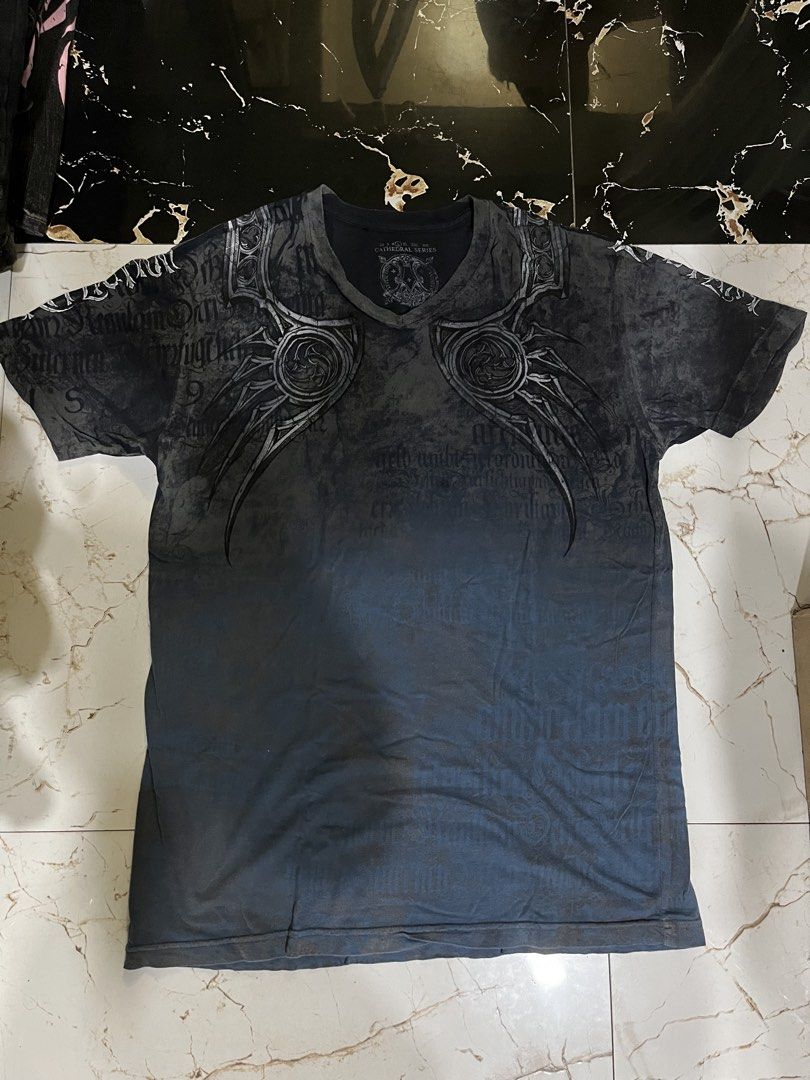 Affliction Cathedral Series T-Shirt (Category: Tshirts & Polo Shirts ) located in Caloocan City. Submitted by einsteinmi44496 (Listing ID 1460619314, Image 1). Description: - Affliction Cathedral Series T-Shirt - Striking front and back graphic print - Size: e20x29 - Made in USA - Material: 100% Cotton.