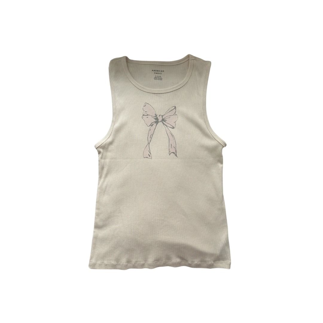 American Eagle Ribbed Tank Top with Bow Graphic (Category: Sleeveless) located in Manila. Submitted by _swaganikaa (Listing ID 1460687102, Image 1). Description: Cream colored ribbed tank top from American Eagle. Features a cute grey and pink bow graphic on the front. Sleeveless design, perfect for warmer weather or layering. The ribbed texture adds a nice touch. Size S..