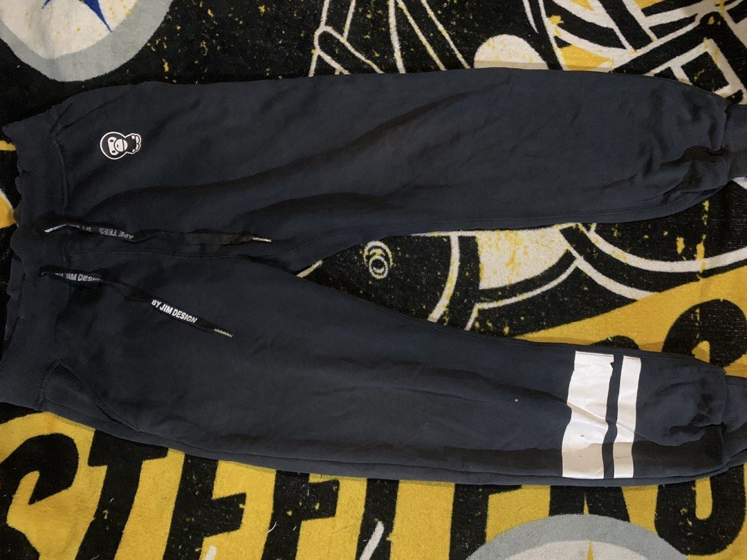 Ape Tees by Jim Design Sweatpants (Category: Joggers) located in San Carlos. Submitted by jemercagui42788 (Listing ID 1460591113, Image 2). Description: - Brand: Ape Tees by Jim Design - Color: Black - Size: M - Features: Ape graphic on left thigh, large Ape Tees lettering on back, drawstring waist with branded tips, striped detail on right leg..