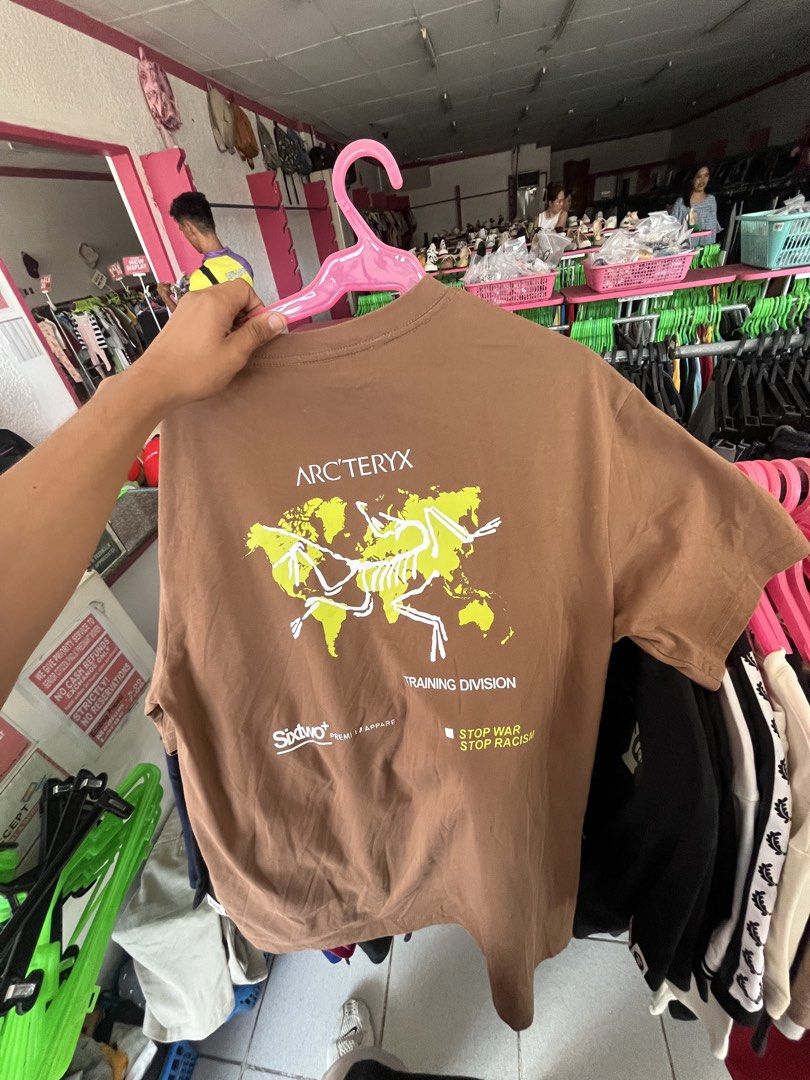 Arc'teryx Training Division T-Shirt - Brown (Category: Tshirts & Polo Shirts ) located in Lapu Lapu. Submitted by vanzfinds_16 (Listing ID 1460597927, Image 2). Description: - Brown Arc'teryx t-shirt - Features Arc'teryx logo on the front - Back graphic: World map with 'Training Division' and 'Stop War Stop Racism' text - Made from comfortable material - Perfect for casual wear.