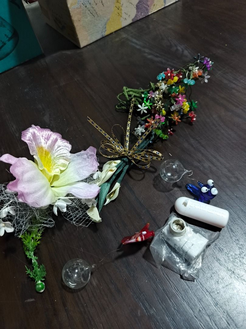 Assorted Aquarium Decor and Floral Accessories (Category: Hair Accessories) located in San Leonardo. Submitted by burgossanleonardo.12345 (Listing ID 1460687050, Image 1). Description: - Bundle of aquarium assorted decorative items. - Large pink & yellow floral accessory with smaller flowers and greenery. - Separate bunch of colorful beaded flowers on a stem. - Includes small floaters glass orbs and a blue glass fish - Also features a white cylin