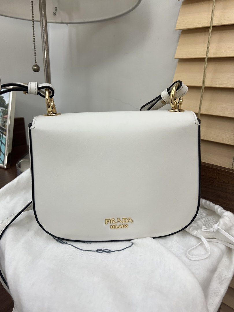 Authentic preloved Prada 1BD239 White leather crossbody bag (Category: Luxury Bags & Wallets) located in San Pablo. Submitted by misskittyph (Listing ID 1460527634, Image 3). Description: Prada 1BD239 White leather saddle crossbody bag ▪️55k only ✨✨Chic, sleek, and effortlessly elegant – the Small White Prada Saddle Crossbody with gold-tone hardware and twist lock adds a touch of luxury to every outfit ✨ . 64% off retail price approx 155k 9/10 co