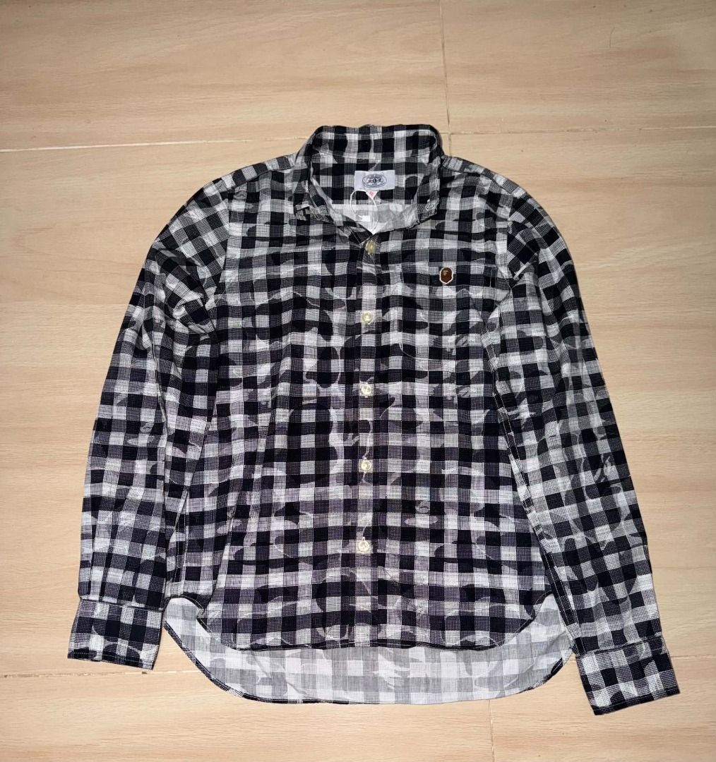 BAPE Black and White Plaid Button-Up Shirt (Category: Tshirts & Polo Shirts ) located in Cainta. Submitted by hermosooo (Listing ID 1460713687, Image 1). Description: - Classic BAPE long-sleeved button-up shirt - Stylish black and white plaid pattern - Features iconic ape head logo on chest pocket - Versatile for pairing with jeans or shorts - Ideal for everyday casual outfits.