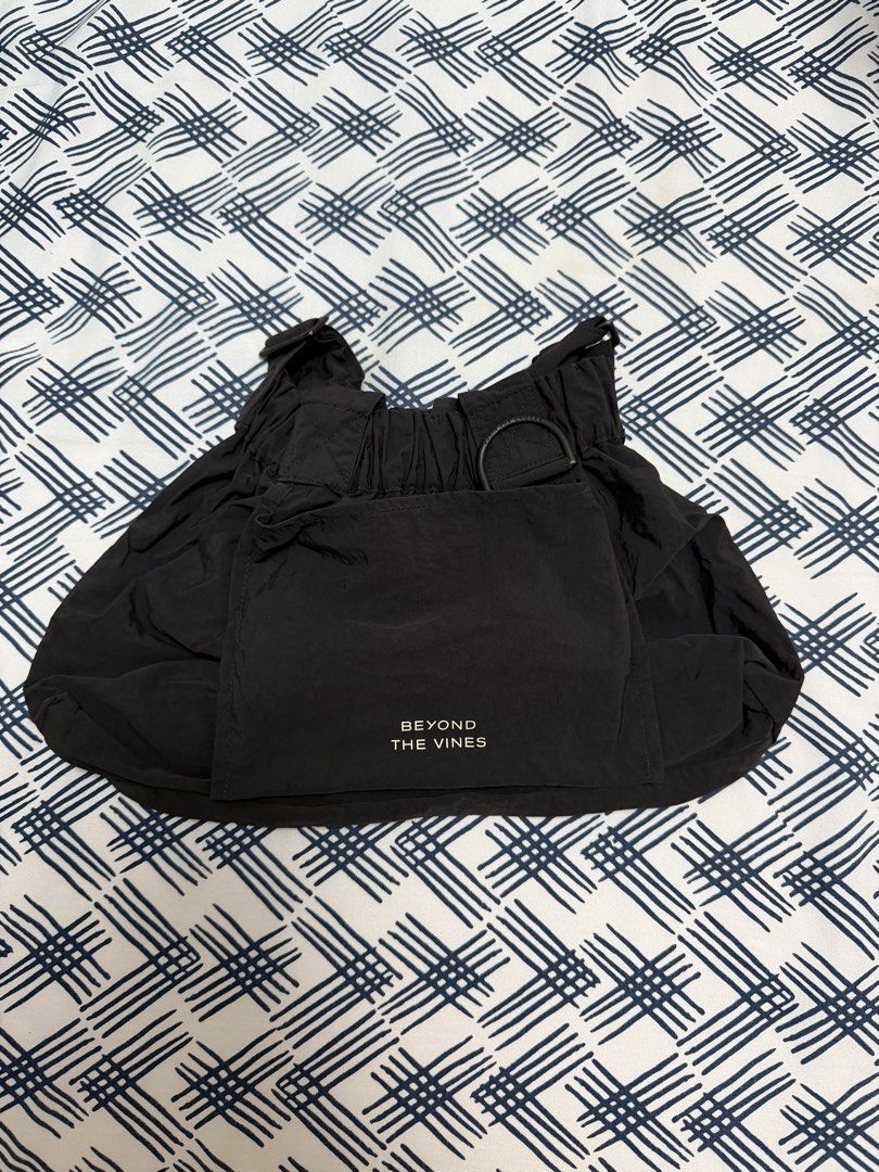Beyond The Vines XS Dumpling Bag (Category: Cross-body Bags) located in Pasig City. Submitted by joy_b_ (Listing ID 1460525782, Image 2). Description: - Brand: Beyond The Vines - Material: Black Nylon - Closure: Drawstring with Magnet for closing the bag - Features: Front pocket with brand logo - Style: Lightweight and versatile - Use: Great for organizing essentials or as a standalone small bag.