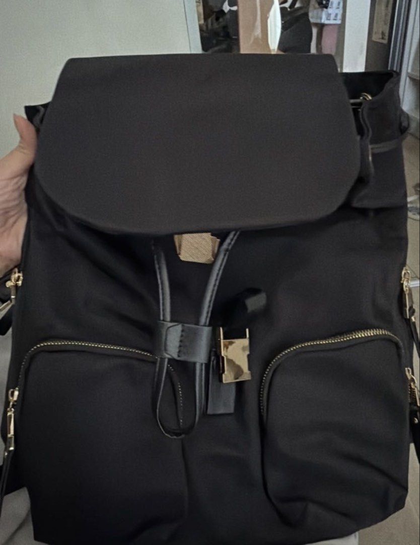 Black Nylon Backpack with Gold Hardware (Category: Backpacks) located in Rizal. Submitted by makhy_21 (Listing ID 1460636306, Image 1). Description: - Stylish black nylon backpack - Secure flap closure with buckle detail - Convenient front zip pockets and side pockets - Elegant gold hardware accents - Ideal for everyday use or travel.