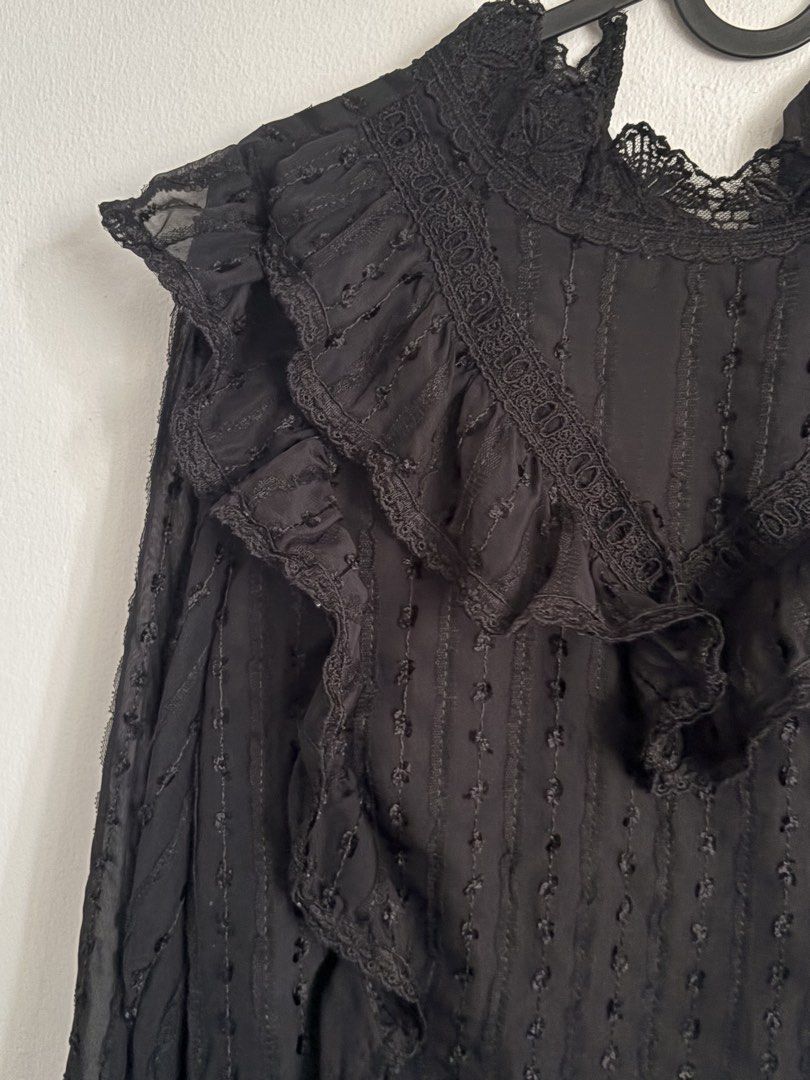 Black Ruffled Lace-Trim Blouse (Category: Blouses) located in Batangas. Submitted by soomi_8 (Listing ID 1460535488, Image 2). Description: Elegant all-black sheer blouse featuring delicate textured dot fabric throughout layered with ruffle detailing across the chest and shoulders It has a high neckline finished with fine scalloped lace, long flowy sleeves with ruffled cuffs, and a subtle keyhole closure at the back Lightweight and semi-sheer per