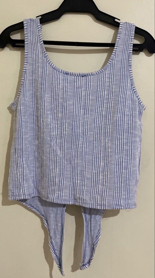 Blue and White Striped Tie-Front Tank Top (Category: Sleeveless) located in Quezon City. Submitted by abssnf (Listing ID 1460514970, Image 2). Description: - Cute blue and white striped tank top - Features a tie-front detail at the bottom - Button accents down the front - Sleeveless design - Ideal for casual wear.