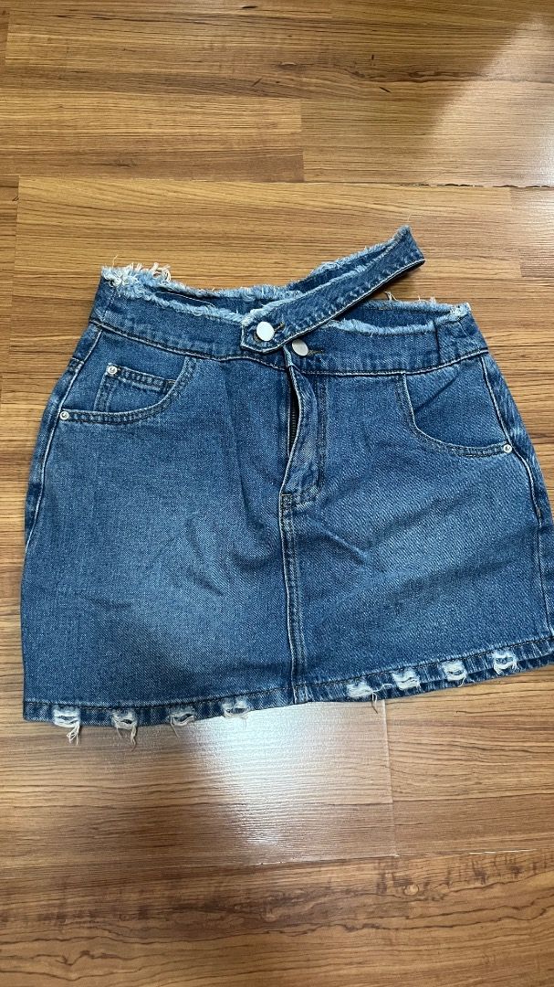 Blue Denim Mini Skirt with Raw Hem (Category: Skirts) located in Taguig. Submitted by fayneayana (Listing ID 1460617486, Image 1). Description: - Size 25-26 - Cute blue denim mini skirt - Features a raw, distressed hemline - Unique asymmetrical waistband with button closure - Front pockets and zip fly - Ideal for casual outfits and easy to pair with tops and sneakers.