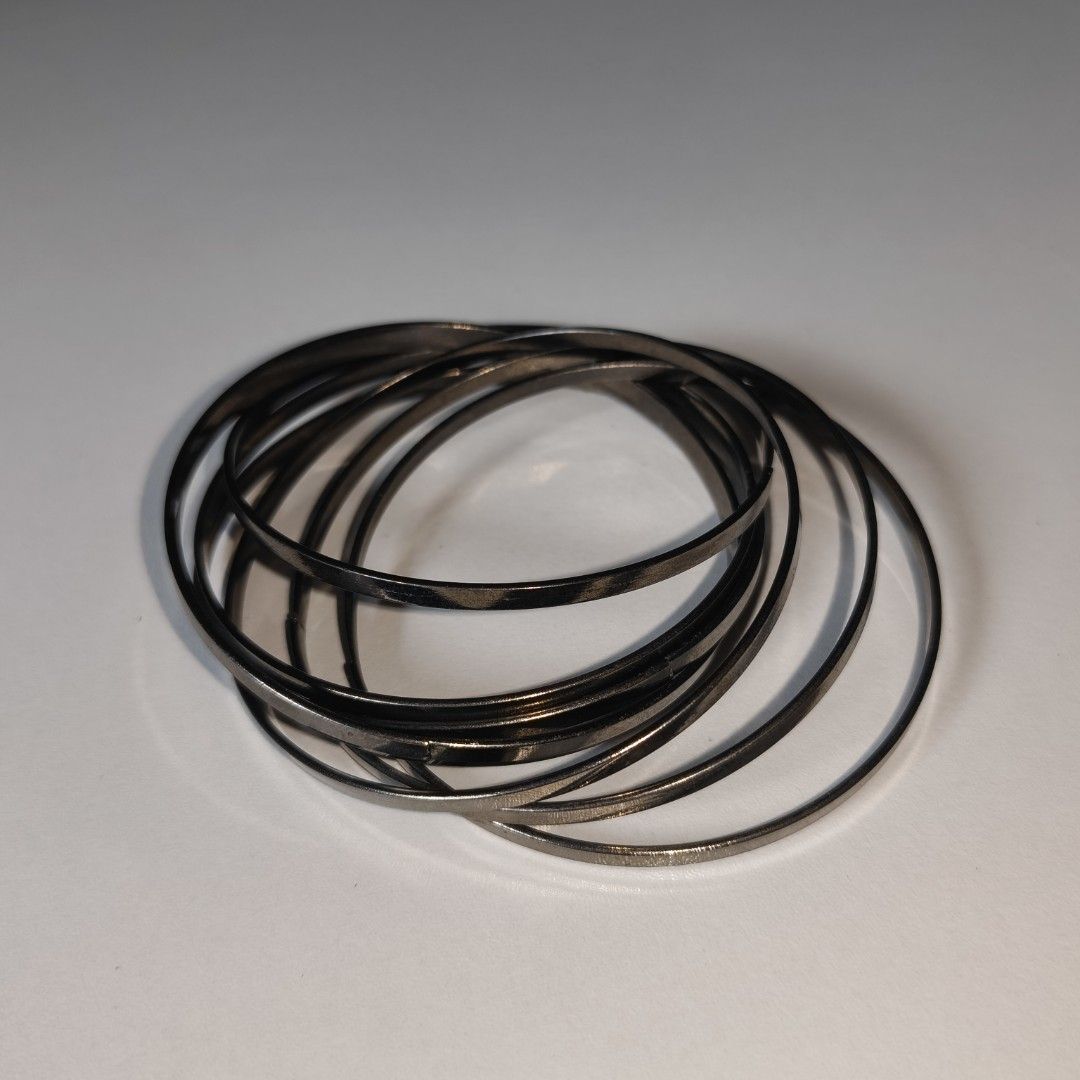 Boho Gunmetal Interlocking Bangle Set - 9pc Textured & Smooth Stack Bracelets (Category: Bracelets) located in Alfonso Lista (Potia). Submitted by ak_collection.03 (Listing ID 1460545009, Image 2). Description: Add a touch of edgy, minimalist flair to your look with this versatile gunmetal-toned bangle bracelet set! This set features an eye-catching, permanently linked multi-strand design that creates a perfect effortless stack. It matches beauti