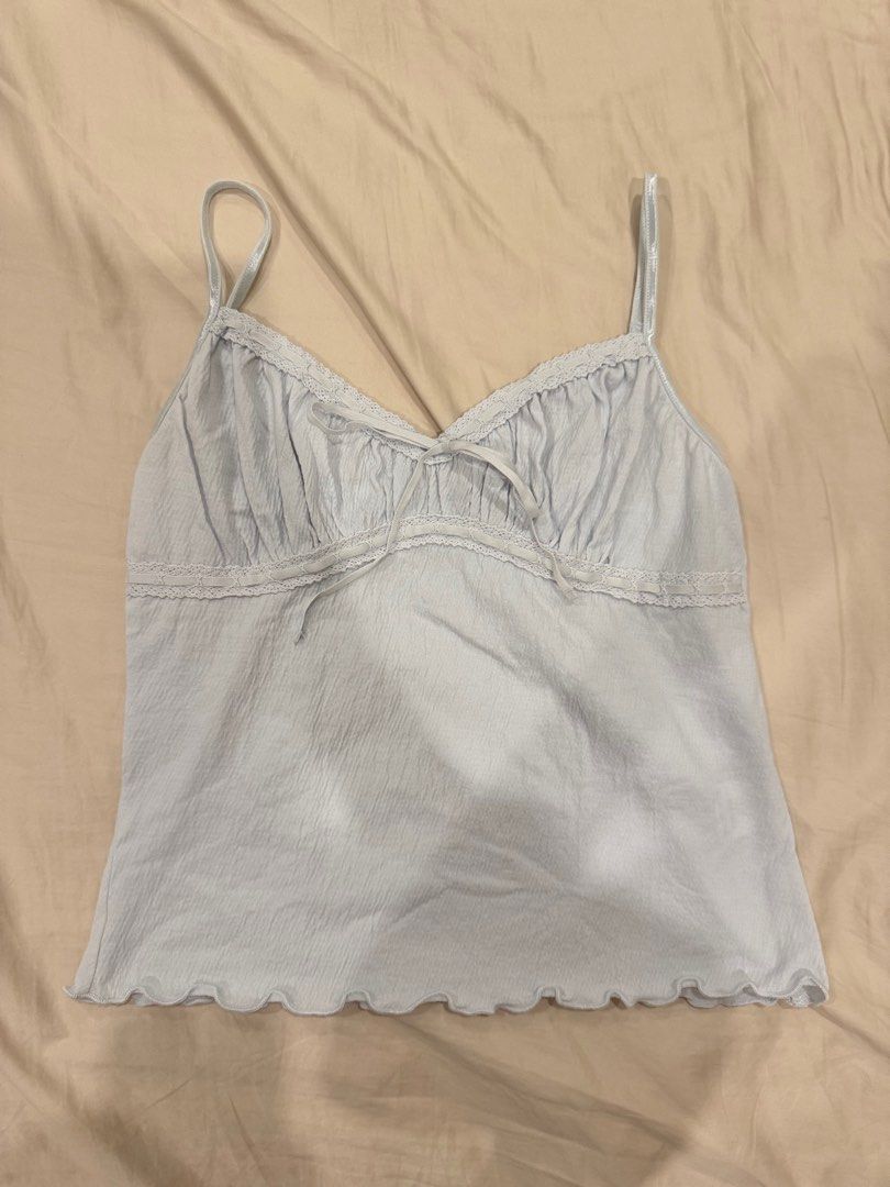 Brandy Melville Light Blue Crinkle Cami Top (Category: Sleeveless) located in Manila. Submitted by pinkyclothes1267 (Listing ID 1460637024, Image 1). Description: - Light blue Brandy Melville cami top - Crinkle texture all over - Lace trim along neckline and hem - Adjustable straps - Tie detail at the back - Lettuce hem finish - Super cute and comfy.