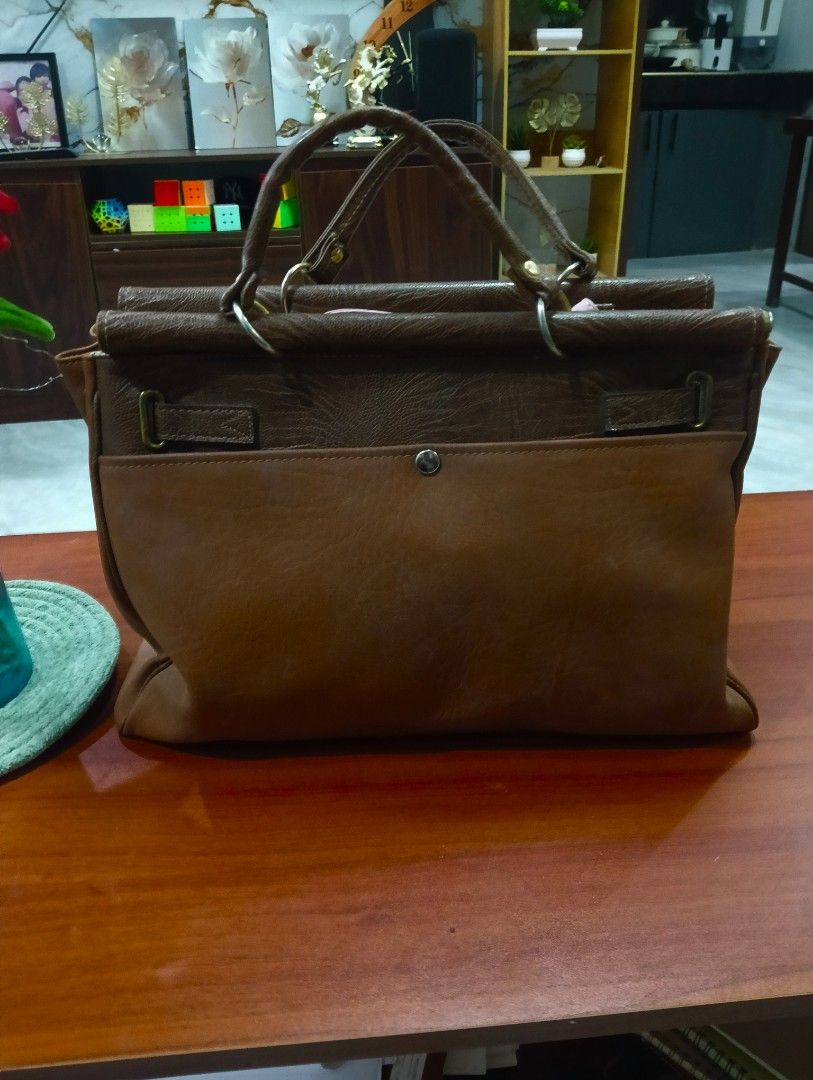 Brown Leather birkin Handbag with Gold Clasp (Category: Luxury Bags & Wallets) located in Odiongan. Submitted by thrifthub_bundang07 (Listing ID 1460665015, Image 2). Description: - Classic brown leather handbag - Secure gold clasp closure at the front - Two top handles for comfortable carrying - Textured leather finish on the upper part - Four protective metal studs on the bottom - Spacious interior, ideal for daily essentials.