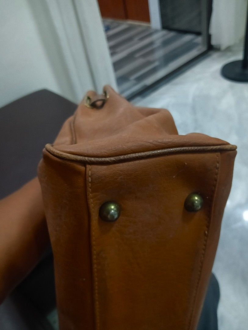 Brown Leather birkin Handbag with Gold Clasp (Category: Luxury Bags & Wallets) located in Odiongan. Submitted by thrifthub_bundang07 (Listing ID 1460665015, Image 3). Description: - Classic brown leather handbag - Secure gold clasp closure at the front - Two top handles for comfortable carrying - Textured leather finish on the upper part - Four protective metal studs on the bottom - Spacious interior, ideal for daily essentials.
