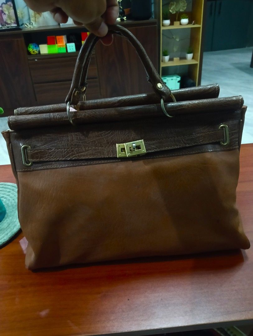 Brown Leather birkin Handbag with Gold Clasp (Category: Luxury Bags & Wallets) located in Odiongan. Submitted by thrifthub_bundang07 (Listing ID 1460665015, Image 1). Description: - Classic brown leather handbag - Secure gold clasp closure at the front - Two top handles for comfortable carrying - Textured leather finish on the upper part - Four protective metal studs on the bottom - Spacious interior, ideal for daily essentials.