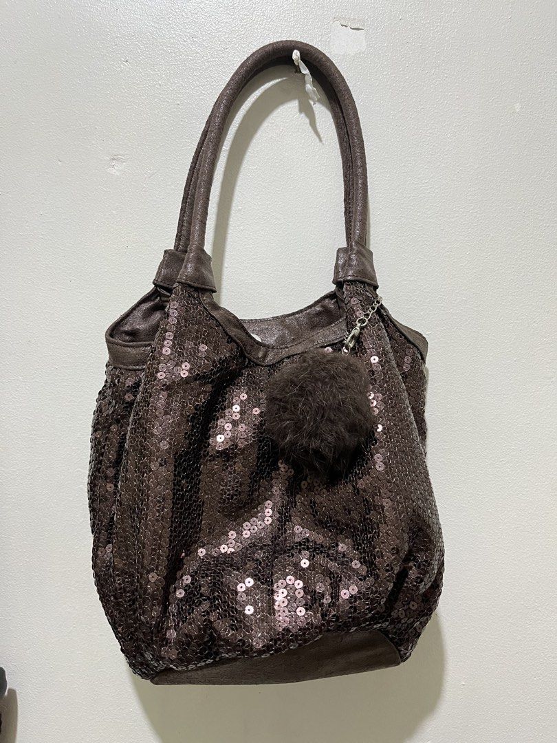 Brown Sequin Bag with Fur Pom Pom Charm (Category: Shoulder Bags) located in Angeles City. Submitted by melloromi (Listing ID 1460576169, Image 1). Description: - Cute brown shoulder bag - Covered in shiny sequins - Soft leather-like trim and handles - Detachable fluffy brown pom pom charm with silver chain - Magnetic snap closure - Spacious interior for essentials - Ideal for evening events or everyday sparkle.