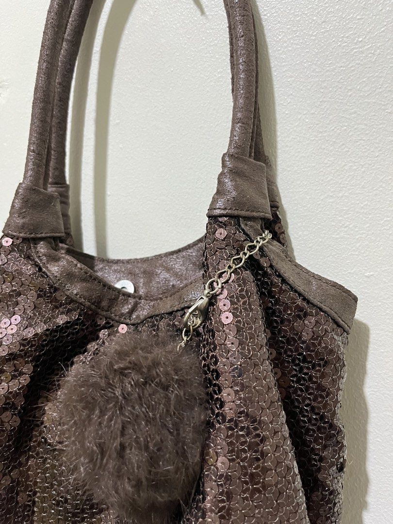 Brown Sequin Bag with Fur Pom Pom Charm (Category: Shoulder Bags) located in Angeles City. Submitted by melloromi (Listing ID 1460576169, Image 2). Description: - Cute brown shoulder bag - Covered in shiny sequins - Soft leather-like trim and handles - Detachable fluffy brown pom pom charm with silver chain - Magnetic snap closure - Spacious interior for essentials - Ideal for evening events or everyday sparkle.
