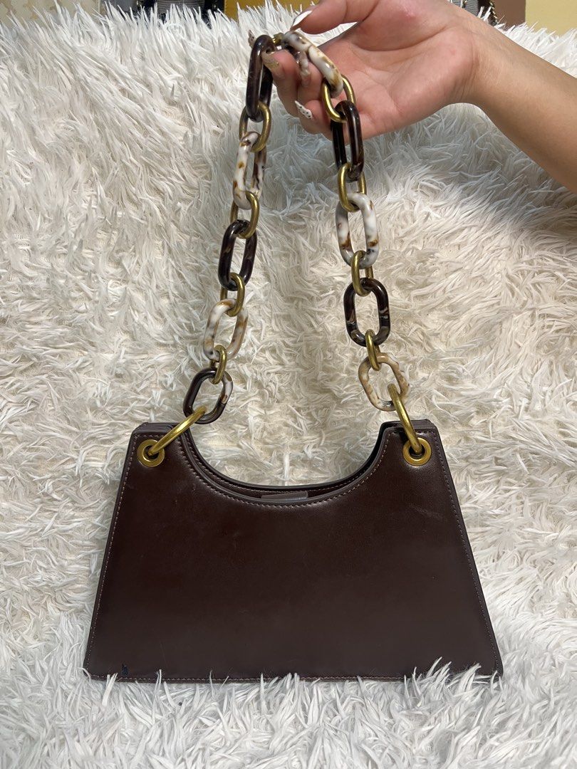 Brown Structured Handbag with Tortoiseshell Chain Strap (Category: Shoulder Bags) located in Manila. Submitted by yanya97 (Listing ID 1460541776, Image 1). Description: - Stylish brown structured handbag - Unique tortoiseshell and gold chain strap - Interior features multiple card slots - Secure snap closure - Convenient for organizing essentials - Elegant gold hardware details - Versatile for day or night use.