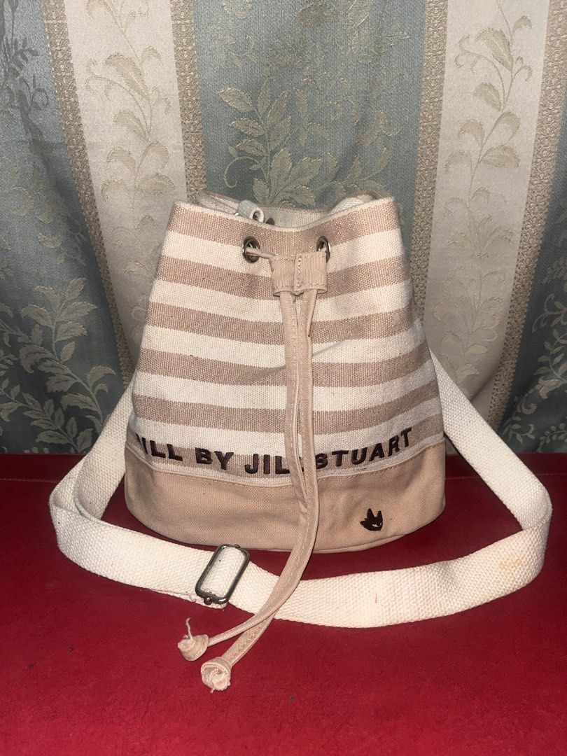Bucket bag (Category: Sling Bags) located in Davao. Submitted by janna_soleil (Listing ID 1460621910, Image 1). Description: beige and white striped canvas bucket bag by Jill by Jill Stuart featuring a drawstring closure and a small embroidered logo at the base.