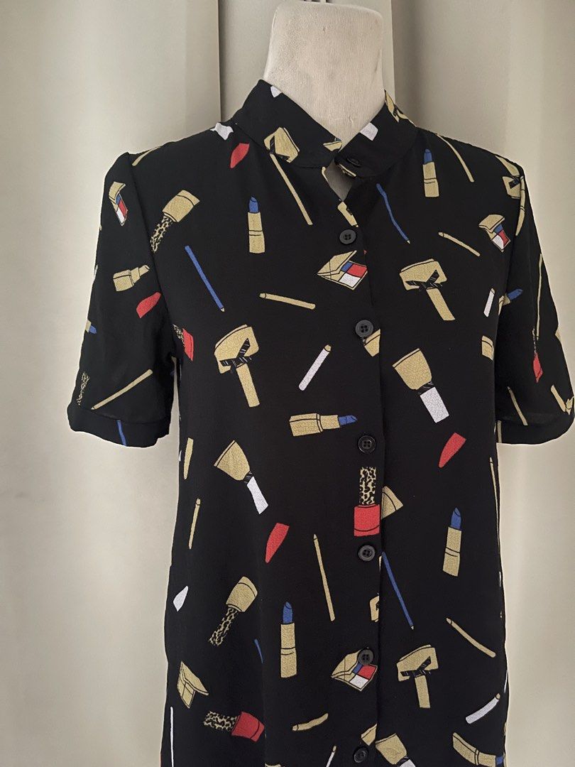 Button-Up Shirt Dress (Category: Dresses) located in Cainta. Submitted by zlove111 (Listing ID 1460530555, Image 2). Description: - Fun black shirt dress - Features a cool lipstick and makeup print - Short sleeves - Button-up front - Stand-up collar - Slightly flared hemline - Ideal for casual outings or themed events - Easy to wear and style medium flowy chiffon not see through up to 36 bust 30 waist length 33.