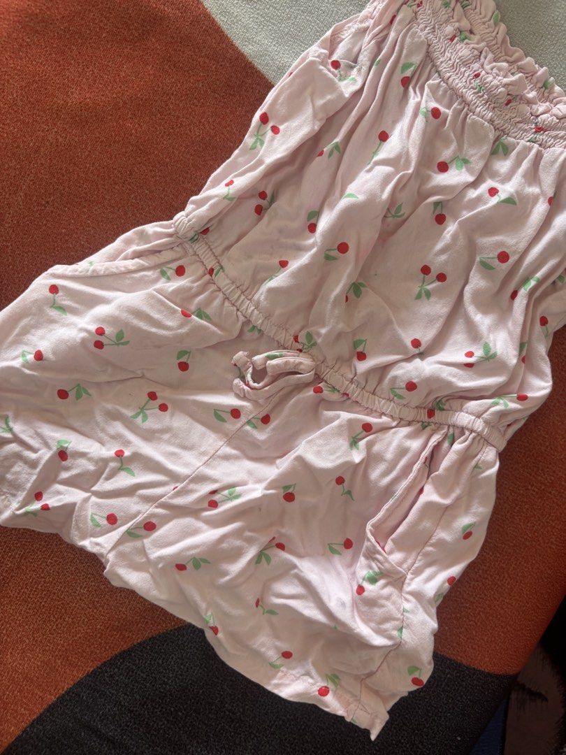 Cat & Jack Pink Cherry Print Romper 2T (Category: Babies & Kids Fashion) located in Alicia. Submitted by thriftbagph (Listing ID 1460657429, Image 2). Description: - Adorable pink romper with a sweet cherry print. - Features a comfortable smocked top and cute ruffled sleeves. - Elastic waistband with an adjustable drawstring tie for a perfect fit. - Convenient side pockets for your essentials. - Lightweight and breathable, ideal for warm weather.