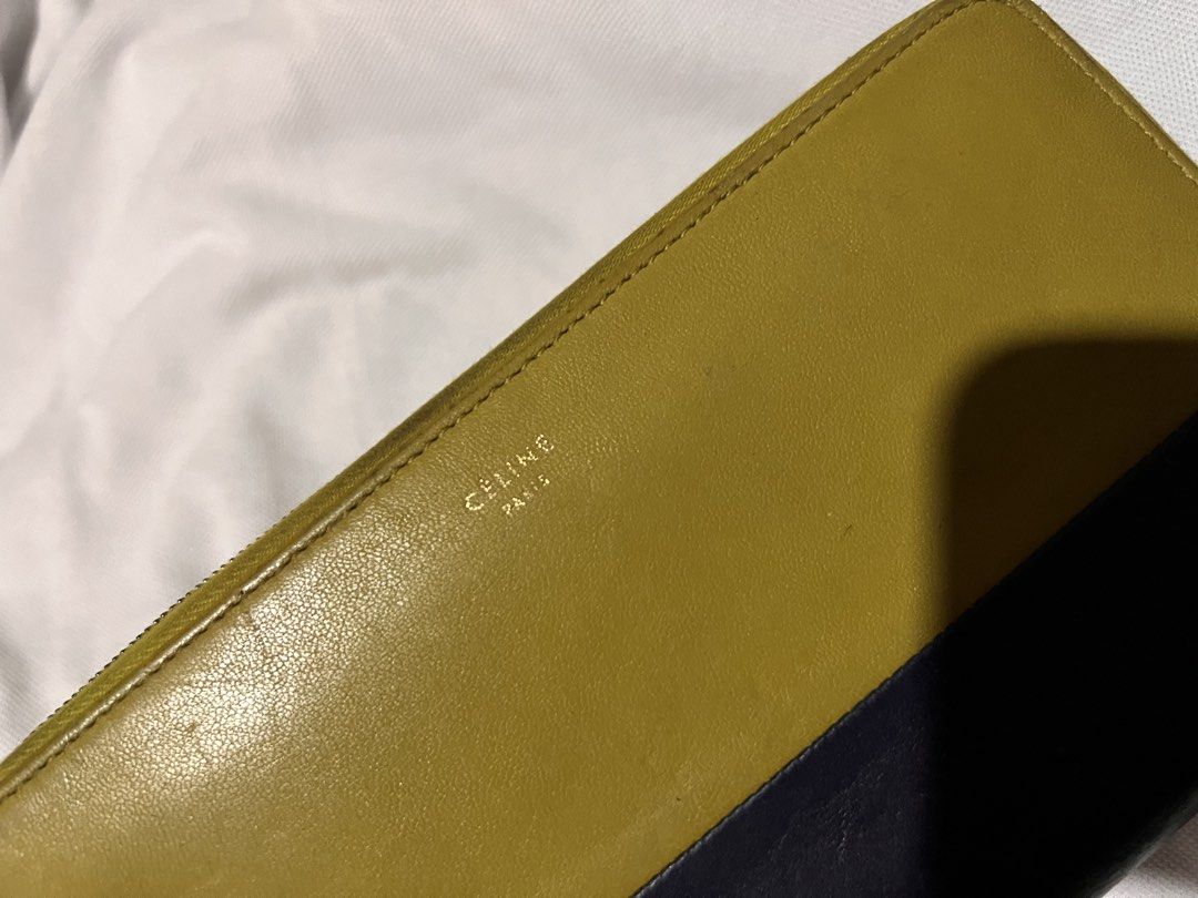 Celine Paris Leather Zip Around Wallet (Category: Wallets & Card holders) located in Quezon City. Submitted by rizza14ortiz (Listing ID 1460524044, Image 2). Description: - Authentic Celine Paris zip-around wallet - Stylish two-tone design: yellow and navy leather - Features multiple card slots and compartments inside - Secure zipper closure - Expertly crafted in Italy - Minor signs of wear on exterior edges and corners - Interior is clean and we