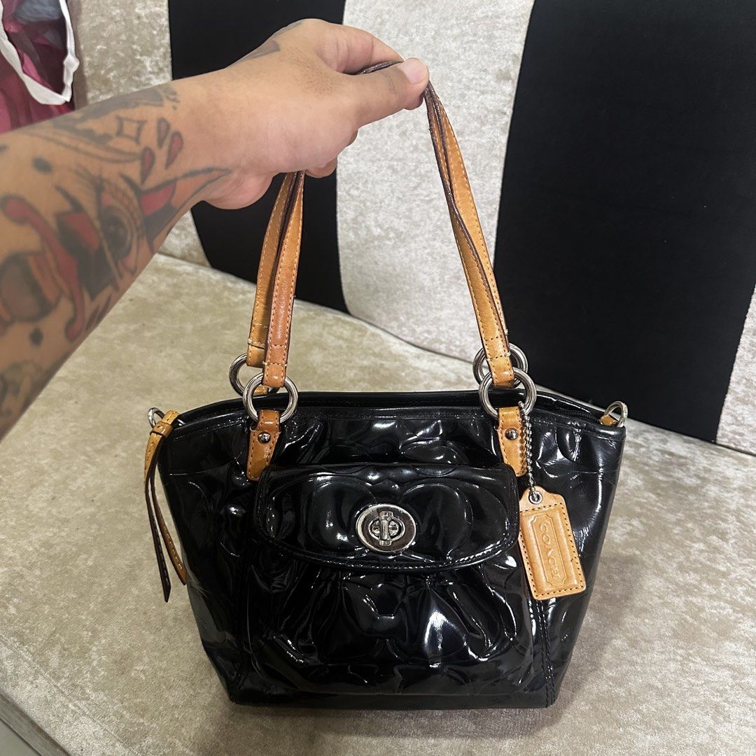Coach Black Patent Leather Embossed Handbag (Category: Luxury Bags & Wallets) located in Quezon City. Submitted by retroboominwantsummoh (Listing ID 1460572528, Image 3). Description: - Black patent leather Coach handbag - All-over embossed Coach logo - Tan leather straps and trim - Front pocket with turn-lock closure - Includes Coach hangtag - Ideal for everyday use.