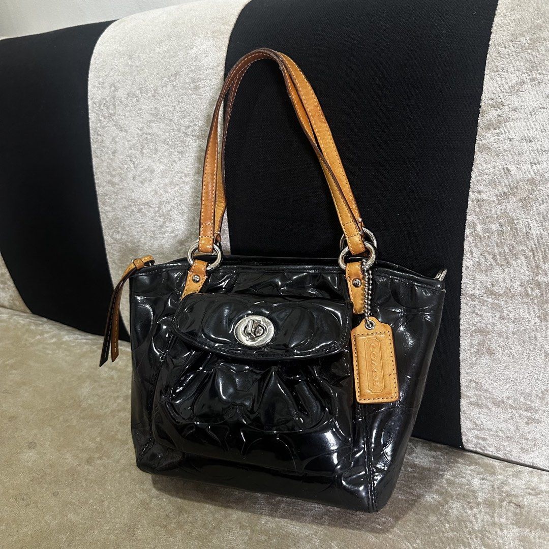 Coach Black Patent Leather Embossed Handbag (Category: Luxury Bags & Wallets) located in Quezon City. Submitted by retroboominwantsummoh (Listing ID 1460572528, Image 1). Description: - Black patent leather Coach handbag - All-over embossed Coach logo - Tan leather straps and trim - Front pocket with turn-lock closure - Includes Coach hangtag - Ideal for everyday use.