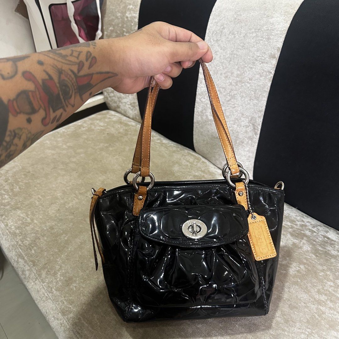 Coach Black Patent Leather Embossed Handbag (Category: Luxury Bags & Wallets) located in Quezon City. Submitted by retroboominwantsummoh (Listing ID 1460572528, Image 2). Description: - Black patent leather Coach handbag - All-over embossed Coach logo - Tan leather straps and trim - Front pocket with turn-lock closure - Includes Coach hangtag - Ideal for everyday use.