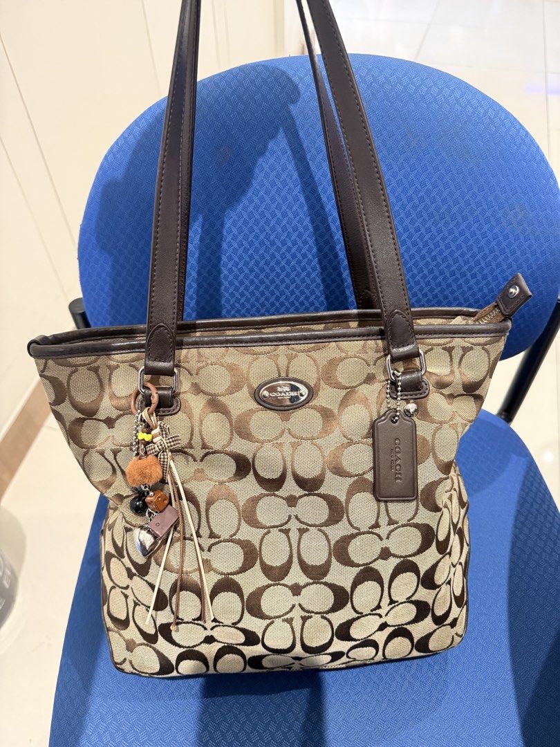 Coach Monogram Canvas Tote Bag with Leather Trim (Category: Luxury Bags & Wallets) located in Manila. Submitted by angelcurated (Listing ID 1460567837, Image 1). Description: - Classic Coach monogram tote bag - Color: Brown and tan signature 'C' pattern - Material: Leather handles and trim - Closure: Top zipper - Exterior: Front zipper pocket - Extras: Comes with cute bag charms - Interior: Plenty of space for essentials - Style: Great everyday b