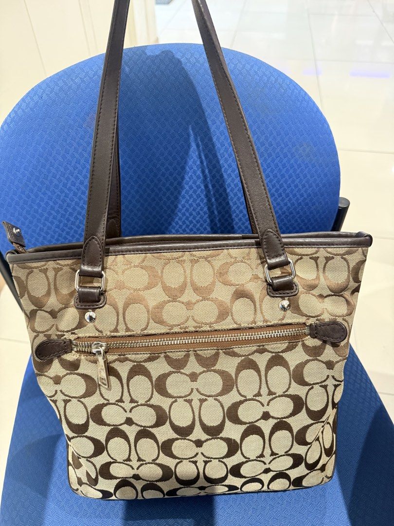 Coach Monogram Canvas Tote Bag with Leather Trim (Category: Luxury Bags & Wallets) located in Manila. Submitted by angelcurated (Listing ID 1460567837, Image 2). Description: - Classic Coach monogram tote bag - Color: Brown and tan signature 'C' pattern - Material: Leather handles and trim - Closure: Top zipper - Exterior: Front zipper pocket - Extras: Comes with cute bag charms - Interior: Plenty of space for essentials - Style: Great everyday b