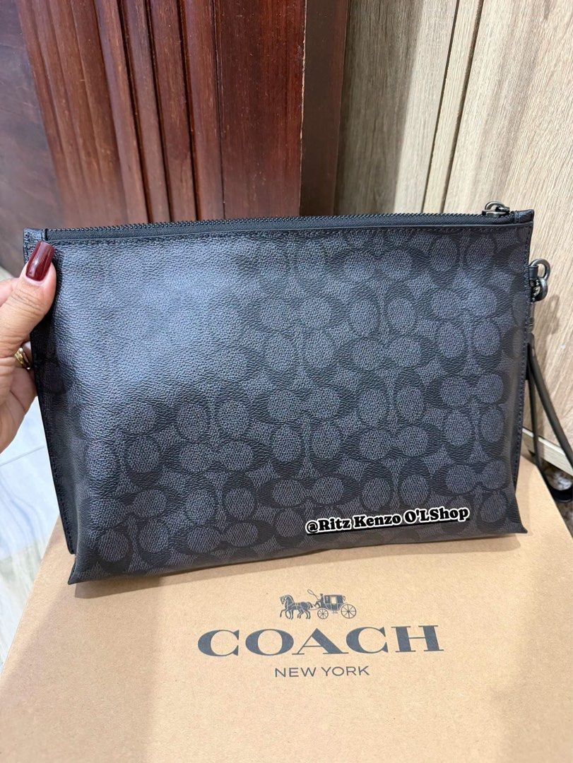Coach Signature Monogram Clutch Bag (Category: Clutches) located in Antipolo. Submitted by ritzkenzo_olshop06 (Listing ID 1460537257, Image 2). Description: - Authentic Coach clutch bag - Signature monogram print in black and grey - Main zippered compartment - Front zippered pocket - Interior card slots and small pouch - Detachable wrist strap - Includes original dust bag and authenticity card - Ideal for everyday use or travel.