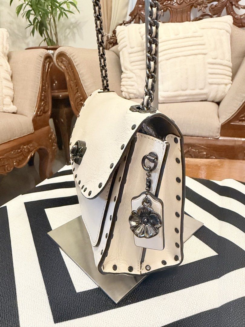 Coach White Leather Studded Chain Shoulder Bag (Category: Shoulder Bags) located in Santiago. Submitted by yrellagnoihsaf (Listing ID 1460704977, Image 2). Description: Coach Parker 18 shoulder bag in chalk leather, accented with dark rivet details and a convertible chain strap.Genuine leather ✅ AUTHENTIC ✅ excellent condition with normal sign if usage no major flaws ✅ no bakbak no rips rubber lining intact ✅ L 7.5” H 6” W 3” ✅ convertible kili o