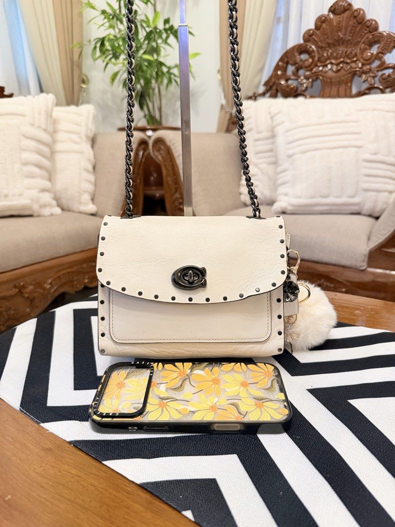 Coach White Leather Studded Chain Shoulder Bag (Category: Shoulder Bags) located in Santiago. Submitted by yrellagnoihsaf (Listing ID 1460704977, Image 1). Description: Coach Parker 18 shoulder bag in chalk leather, accented with dark rivet details and a convertible chain strap.Genuine leather ✅ AUTHENTIC ✅ excellent condition with normal sign if usage no major flaws ✅ no bakbak no rips rubber lining intact ✅ L 7.5” H 6” W 3” ✅ convertible kili o